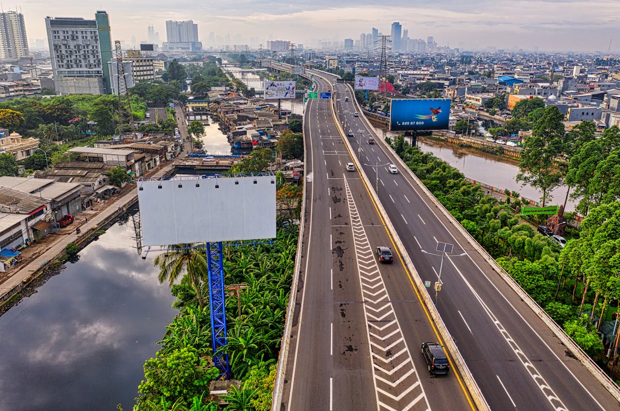 Large roadside billboard overlooking a busy highway, representing sustainable outdoor advertising and ESG-focused marketing campaigns